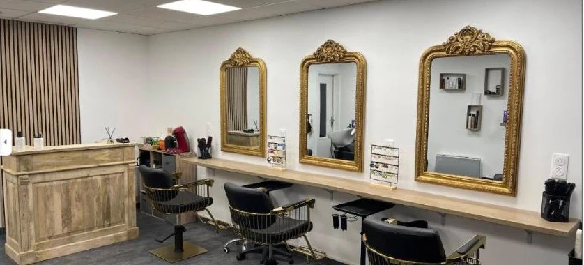 Intérieur du salon Just You à Coudekerque-Branche, miroirs dorés et postes de coiffage